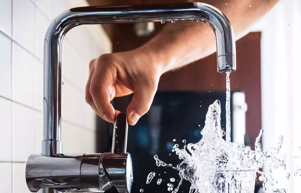 Fast pouring tap water from the faucet into a drinking glass