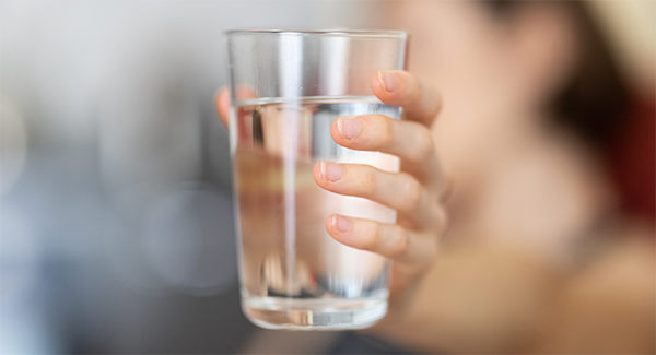 woman holding glass of drinking water