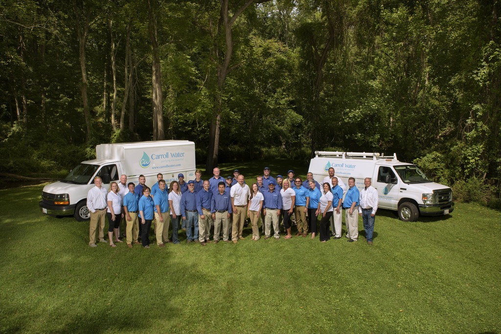 Carroll Water team standing in front of two Carroll Water Trucks