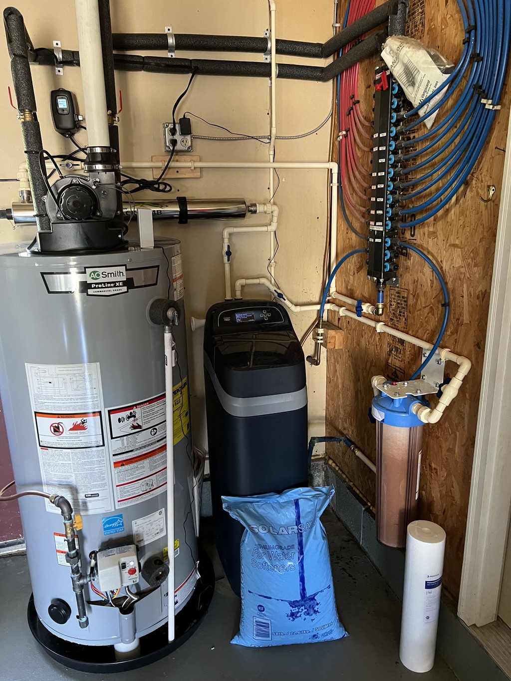 water treatment system next to water heater and a bag of salt