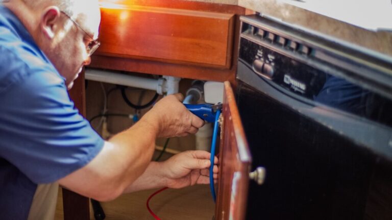Carroll Water technician installing a water treatment system under a sink